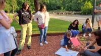 Groep mensen rond een bord in het park