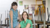 Cindy Van Dijck en Hilde Leon in een leeg klaslokaal, met de stoelen op de banken.