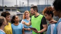 Coach heeft tablet vast en spreekt met team