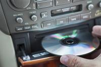 Hand steekt cd in cd-speler