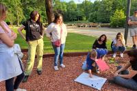 Groep mensen rond een bord in het park