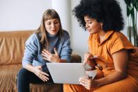Twee vrouwen praten met pc in de hand