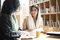Collega's praten met koffie in bibliotheek